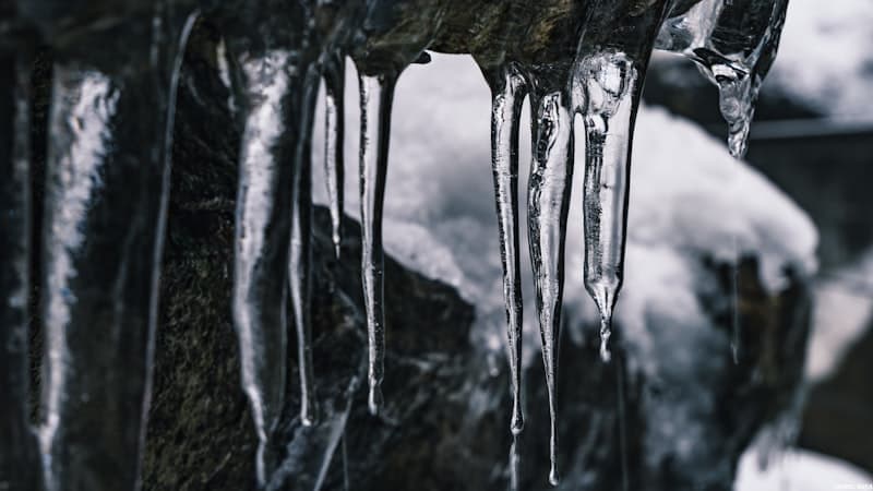 Thermometer showing cold temperature readings next to ice cubes