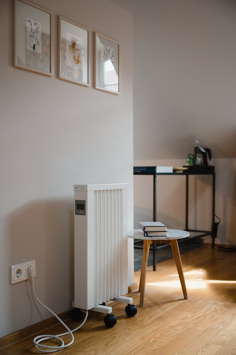 White portable home appliance plugged into a wall outlet running in a corner of a living room, like a basement dehumidifier running up the electric bill