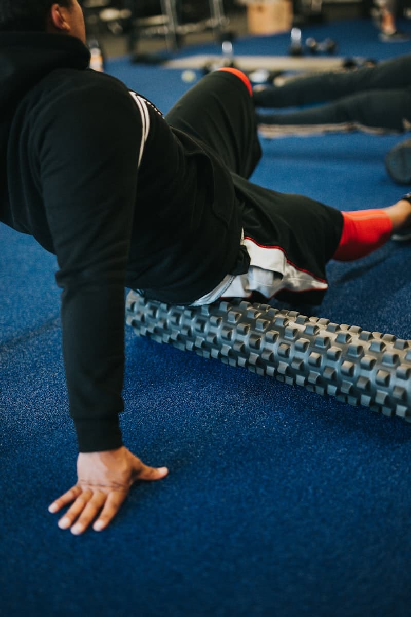 Foam roller and massage gun side by side on a gym mat — which recovery tool is better?