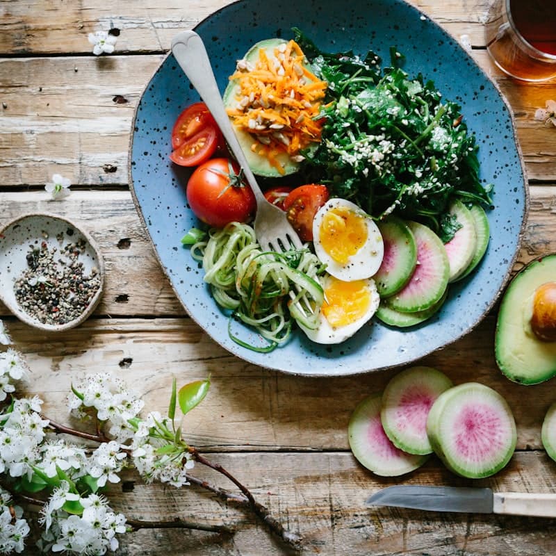 A plate of whole-grain bread and leafy greens beside magnesium capsules, illustrating dietary factors that affect absorption