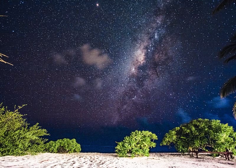 Vivid starry night sky with the Milky Way glowing over a dark beach, capturing the surreal dreamlike quality some ashwagandha users seek out