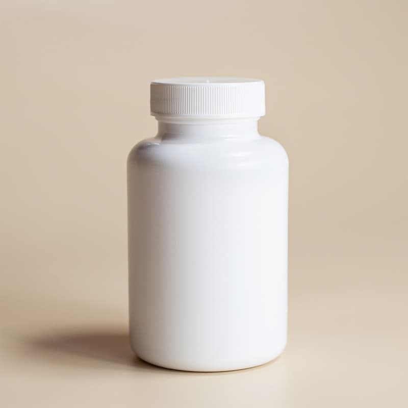 Plain white supplement bottle with a screw-on cap on a neutral background — reading the ingredient label to avoid bloating triggers