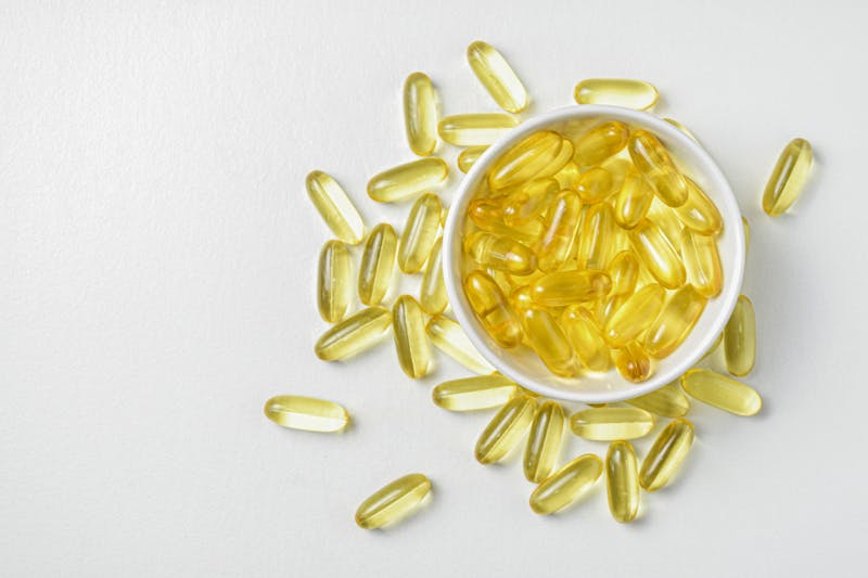Omega-3 fish oil capsules with fresh salmon and healthy fats for heart and brain health